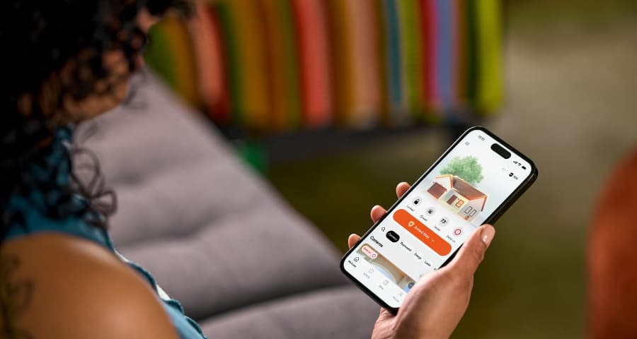 Homeowner using the HomeView feature in the Vivint app to manage automation, security, and energy usage.