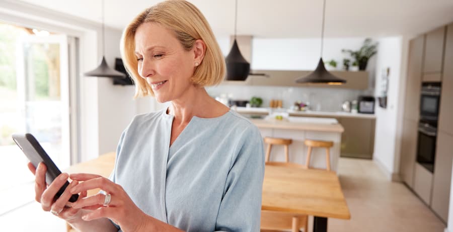 Resident holding a smartphone in a room filled with sunlight